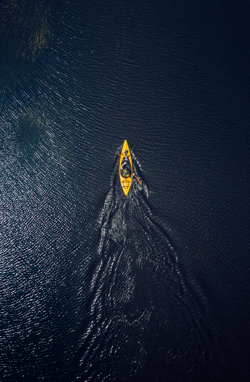 yellow and black surfboard on body of water