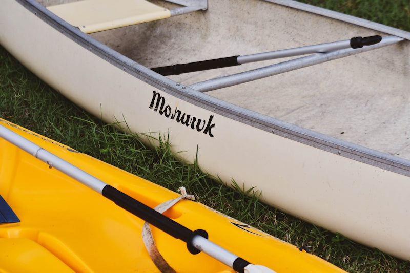 white and yellow kayak on green grass