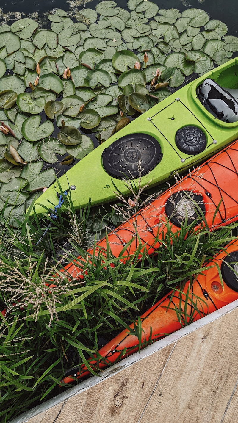 a kayak sitting on top of a body of water surrounded by lily pads