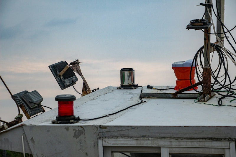 Marine equipment, lights, and wires on a boat's cabin.